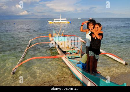 Junge Mädchen, die auf einem bangka-Boot in Malapascua, Central Visayas, den Philippinen stehen. Stockfoto