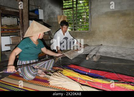 Ein Mattenweber, der in seinem Haus in einem kleinen Dorf in Cẩm Kim, Hội an, Vietnam arbeitet. Stockfoto