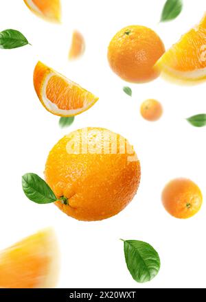 Orangen mit Scheiben und Blättern fliegen in der Luft Stockfoto