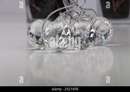 Eine Gruppe von aufgeschnittenen Glaskugeln, die auf einer weißen Oberfläche mit echten Schatten liegen, Nahaufnahme Stockfoto