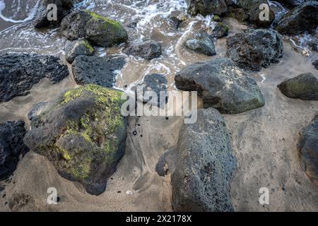 Große vulkanische Felsen eingebettet in den goldenen Sand des Ka'anapali Beach in Lahaina, Hawaii auf der Insel Maui. Stockfoto