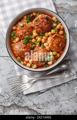 Nahost-Lammfleischbällchen mit Kichererbsen in Tomatensauce in einer Schüssel auf dem Tisch. Vertikale Draufsicht von oben Stockfoto