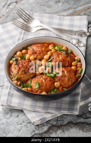 Nahost-Lammfleischbällchen mit Kichererbsen in Tomatensauce in einer Schüssel auf dem Tisch. Vertikal Stockfoto