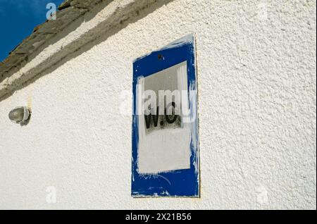 Das wc-Schild ist auf die weiß getünchte Wand gemalt Stockfoto