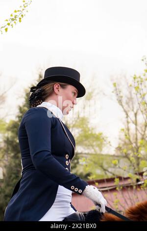 Nahaufnahme eines Dressurreiters in traditioneller Kleidung. Fahrsitzung. Weiblicher Jockey im Uniform-Reitpferd. Pferdesport. Reitschule Stockfoto