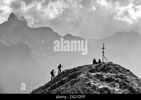 Zwei Frauen klettern auf den Gipfel des Rötelsteins, Dachsteingruppe im Hintergrund, bei Rötelstein, Dachstein, Salzburg, Österreich Stockfoto