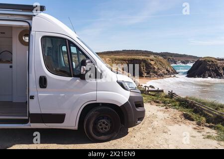 Eleganter, handgefertigter Wohnmobil, der vor dem Strand am Meer geparkt wird Stockfoto