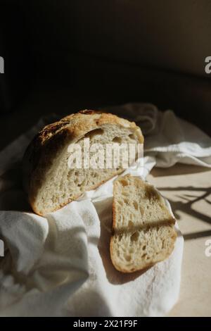 Frisch geschnittener Sauerteig auf weißem Geschirrtuch in der Sonne Stockfoto