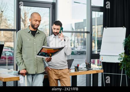 Zwei Geschäftsleute stehen nebeneinander in einem Büro und diskutieren über ein Projekt. Stockfoto