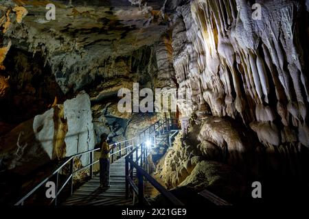 Frau, die allein in einer großen Höhle steht Stockfoto