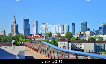 Warschau, Polen. 11. April 2024. Brücke über die Weichsel, die nur für Fußgänger und Radfahrer bestimmt ist. Im Hintergrund ein Panorama der Stadt mit Stockfoto