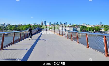 Warschau, Polen. 11. April 2024. Brücke über die Weichsel, die nur für Fußgänger und Radfahrer bestimmt ist. Im Hintergrund ein Panorama der Stadt mit Stockfoto