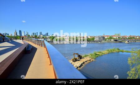 Warschau, Polen. 11. April 2024. Brücke über die Weichsel, die nur für Fußgänger und Radfahrer bestimmt ist. Im Hintergrund ein Panorama der Stadt mit Stockfoto