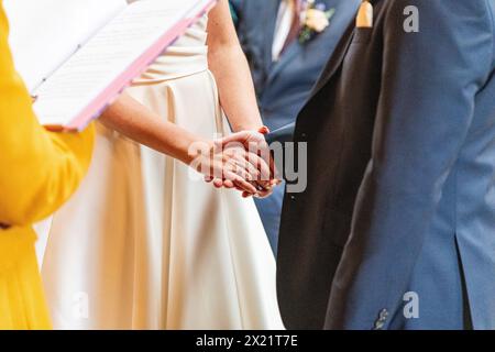 Ein Brautpaar tauscht bei einer Zeremonie während einer Hochzeit auf der Botley Hill Farm in Surrey, Großbritannien, Ehegelübde und Ringe aus Stockfoto