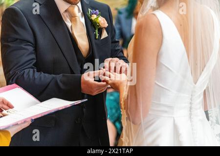 Ein Brautpaar tauscht bei einer Zeremonie während einer Hochzeit auf der Botley Hill Farm in Surrey, Großbritannien, Ehegelübde und Ringe aus Stockfoto