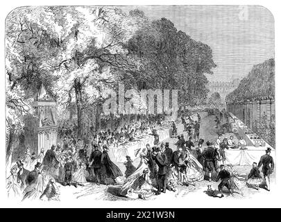 Fest des Fürsten Imperial an die armen Kinder von Paris in den Tuilerien, 1864. Die Beamten des Hauses des Kaisers hatten dafür gesorgt, dass eine große Zahl von Besuchern, sowohl alt als auch jung, befriedigt werden konnte. Eine lange Reihe von Tischen, die mit weißem Damast bestreut waren, mit Kuchen- und Weinvorräten, erstreckte sich vor der Terrasse... die anwesenden Kellner waren Diener in der kaiserlichen Lackierung, mit ein paar Soldaten... es gab verschiedene Vergnügungen, wie eine Ausstellung von Seilvorführungen, Karussell, Puppe - Shows, Punch und Judy (in der Stockfoto