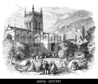 Tagung der British Association in Birmingham: Priory Church, Malvern, 1865. '...die Geologen... wo sie von Dr. Harvey B. Hall empfangen wurden... die schöne gotische Priorienkirche wurde inspiziert, und ihre sehr reiche und leichte Architektur wurde sehr bewundert. Das Kirchenschiff ist im normannischen Stil gehalten und das Dach ist exquisit verziert; sein florierender gotischer Mittelturm, 124 ft. Hoch, wird von Zinnen und Zinnen übersät. Vom Rest des Klosters, das ursprünglich von Eduard dem Bekenner gestiftet wurde, bleibt allein das große Tor, ein reines Beispiel für den spitzen Stil, und in Anbetracht seiner Antike, ist es Stockfoto
