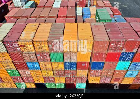 Ein Haufen intermodaler Container in verschiedenen Farben, die an Bord eines Frachtcontainers geladen werden können. Konzept der Standardfracht-gerechten Versandart Stockfoto