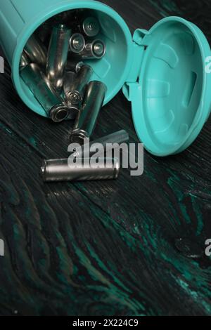 Ein umweltfreundliches Konzept auf einem Foto: Entsorgte Fingerbatterien in einem kleinen Abfallbehälter, die die Zuschauer dazu bringen, Elektronik verantwortungsvoll zu recyceln. Stockfoto