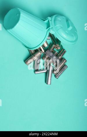 Miniaturszene mit einer starken Botschaft: Alte Fingerbatterien in einem winzigen Abfalleimer, die sich für Recycling und Umweltbewusstsein einsetzen Stockfoto