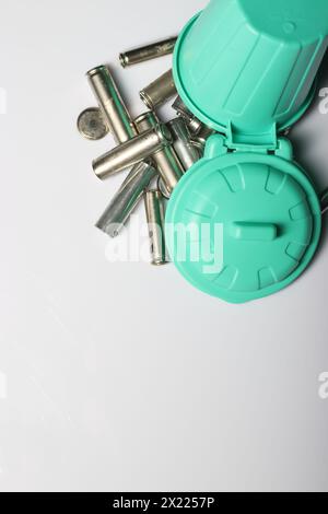 Miniaturszene mit einer starken Botschaft: Alte Fingerbatterien in einem winzigen Abfalleimer, die sich für Recycling und Umweltbewusstsein einsetzen Stockfoto