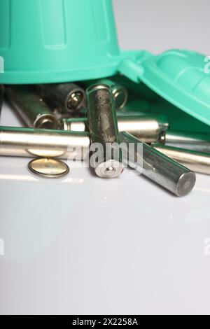 Miniaturszene mit einer starken Botschaft: Alte Fingerbatterien in einem winzigen Abfalleimer, die sich für Recycling und Umweltbewusstsein einsetzen Stockfoto