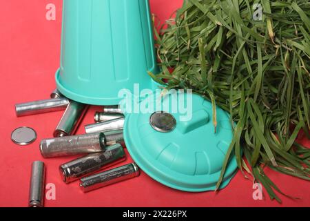 Kreative Präsentation von recycelten Fingerbatterien in einem kleinen Abfalleimer, die Zuschauer dazu ermutigen, nachhaltige Gewohnheiten für einen saubereren Planeten zu übernehmen. Stockfoto