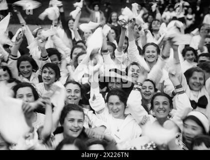 Public Schools Athletic League, zwischen 1910 und 1915. Zeigt eine Menge Mädchen, die Taschentücher winken und lächeln; möglicherweise jubeln. Stockfoto