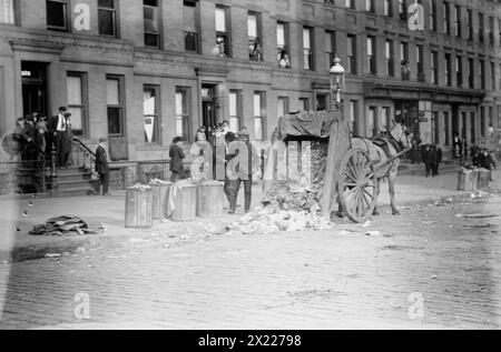 New Yorks Straßen, 1911. Zeigt einen von Pferden gezogenen Müllwagen, dessen Ladung während eines Müllstreiks in New York City vom 8. Bis 11. November 1911 auf die Straße geworfen wurde. Stockfoto