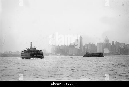 Skyline - N.Y.C.: Woolworth Bldg., Singer Bldg., Bankers Trust Bldg., (1912?). Zeigt Lower Manhattan, New York City, mit Fähre im Vordergrund. Zu den identifizierten Gebäuden gehören (von links): Woolworth Building (mit Turm kurz vor Fertigstellung), Hudson Terminal, West Street Building, City Investing Tower, Singer Building, U.S. Realty and Trinity Buildings, United States Express Company, Bankers Trust Tower und 47 West Street Building. Stockfoto