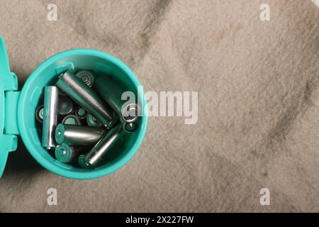 Gebrauchte Fingerbatterien in einem Miniatur-Mülleimer. Auf einem beigefarbenen schmutzigen Hintergrund. Recycling von Abfällen. Stockfoto