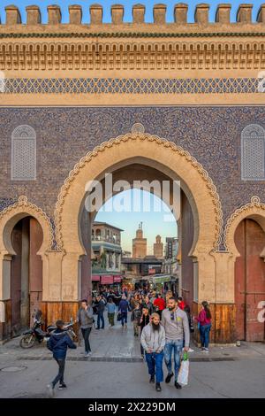 Eine Gruppe von Menschen, die vor dem historischen Bab Boujloud, auch bekannt als das Blaue Tor, in der Medina von Fès, Marokko, spazieren gehen. Stockfoto