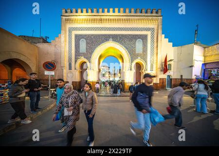 Eine Gruppe von Menschen, die vor dem historischen Bab Boujloud, auch bekannt als das Blaue Tor, in der Medina von Fès, Marokko, spazieren gehen. Stockfoto