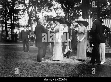 Oscar Straus bei B. Cochrans [d. h. Cockran], 1912. Oscar Straus (1850–1926), Kandidat der Bull Moose Party für das Amt des Gouverneurs von New York im Jahr 1912; er schüttelt die Hand mit Mrs. B. Cochran, während Eleanor B. Roosevelt zusieht. Die Veranstaltung fand im Landhaus des Politikers William Bourke Cockran (1854–1923) in Port Washington, Long Island, New York State statt. Stockfoto