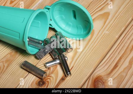 Gebrauchte Fingerbatterien in einem Miniatur-Mülleimer. Auf Pinienbrettern. Nahaufnahme. Stockfoto