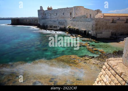 Die Befestigungen von Castello Maniace (Schloss Maniace) auf der Insel Ortigia, Syrakus, Sizilien, Italien, mit klarem und farbenfrohem Wasser Stockfoto