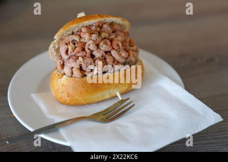 Hamburg, Deutschland. April 2024. ILLUSTRATION - Ein Brötchen mit Nordseekrabben steht auf der Theke einer Fisch-Sandwich-Snackbar bei den Landungsbrücken. Der Preis für Nordseekrabben ist gestiegen. Quelle: Marcus Brandt/dpa/Alamy Live News Stockfoto