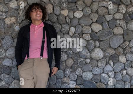 Junger lateinamerikanischer Mann, der mit entspannter und lächelnder Haltung steht Stockfoto