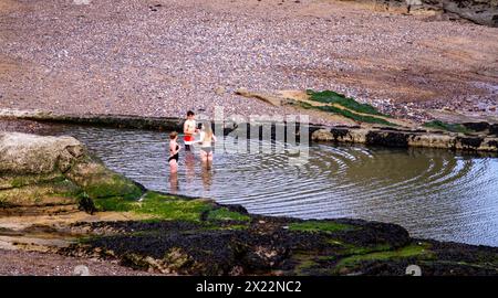 Junge Leute, die sich am Freibad in St. Andrews, Schottland, amüsieren Stockfoto