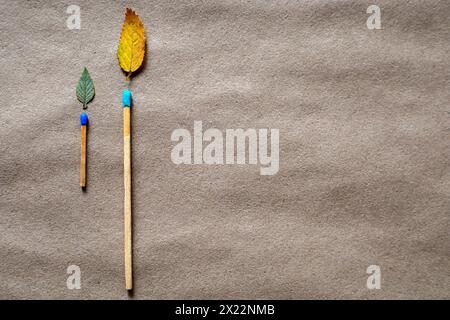 Streichhölzer und grüne Blätter in Form von Flammen. Umweltschutzkonzept Stockfoto