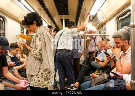 Iranisches Mädchen in einem U-Bahn-Zug in Teheran widersetzt sich dem obligatorischen Hijab, indem es ihr Haar öffentlich zeigt. Stockfoto