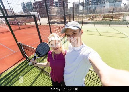 Paddle-Tennis-Team von Frauen und Männern, die im Weitwinkelbild posieren Stockfoto