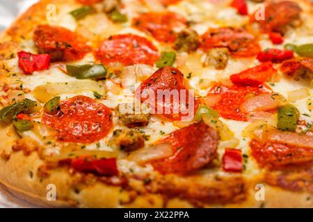 Pepperoni Pizza aus der Nähe. Ein köstliches, frisch gebackenes Fast Food mit Teig, Käse, Tomatensauce und Belägen wie Feinkost und Gemüse. Stockfoto