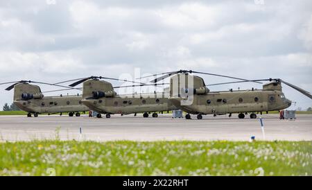 10. April 2024, Bayern, Ansbach: Drei Boeing-Vertol CH-47 Chinook-Transporthubschrauber der US-Armee parken auf dem Flugplatz des US-Militärflugplatzes Katterbach bei Ansbach. Foto: Daniel Karmann/dpa - ACHTUNG: Kennzeichennummern wurden aus rechtlichen Gründen pixeliert Stockfoto