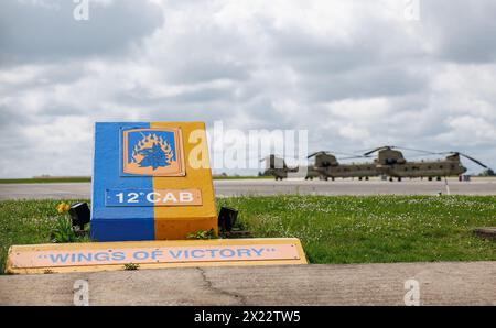 Ansbach, Deutschland. April 2024. Drei Boeing-Vertol CH-47 Chinook Transporthubschrauber der US Army parken auf dem Flugplatz Katterbach bei Ansbach hinter dem Logo der 12th Combat Aviation Brigade (CAB) der US Army. Vermerk: Daniel Karmann/dpa/Alamy Live News Stockfoto