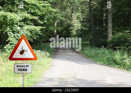 Warnschild für infizierte Zecken im Wald. Risiko von Zecken und Lyme-Borreliose. Stockfoto