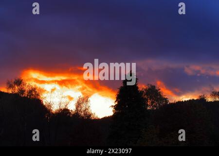 Sonnenuntergang mit dramitischen dunklen Wolken, Sonne scheint durch eine Lücke in den Wolken, roter Himmel, brennender Himmel, Silhouette, Rothaargebirge, Nordrhein-Westfalen Stockfoto