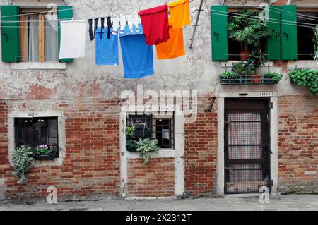 Farbenfrohe Wäsche hängt an einer Wäscheleine vor alten venezianischen Hausfassaden, Venedig, Veneto, Italien Stockfoto