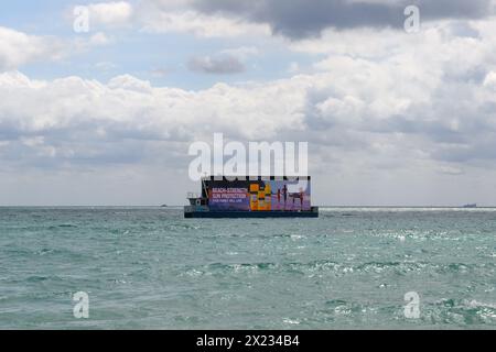 Digitale Offshore-Werbefläche mit Neutrogena Sonnenschutz am Miami Beach South, Florida, USA Stockfoto