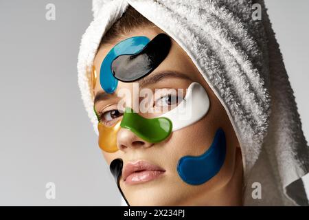 Eine Frau mit einem Handtuch auf dem Kopf, mit Augenflecken im Gesicht. Stockfoto